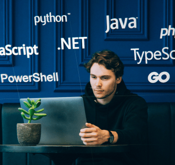 Seated developer in a black hoodie getting started with Microsoft Graph. Surrounding his head are icons for python, java, javascript, typescript, php, dot net, and powershell languages.